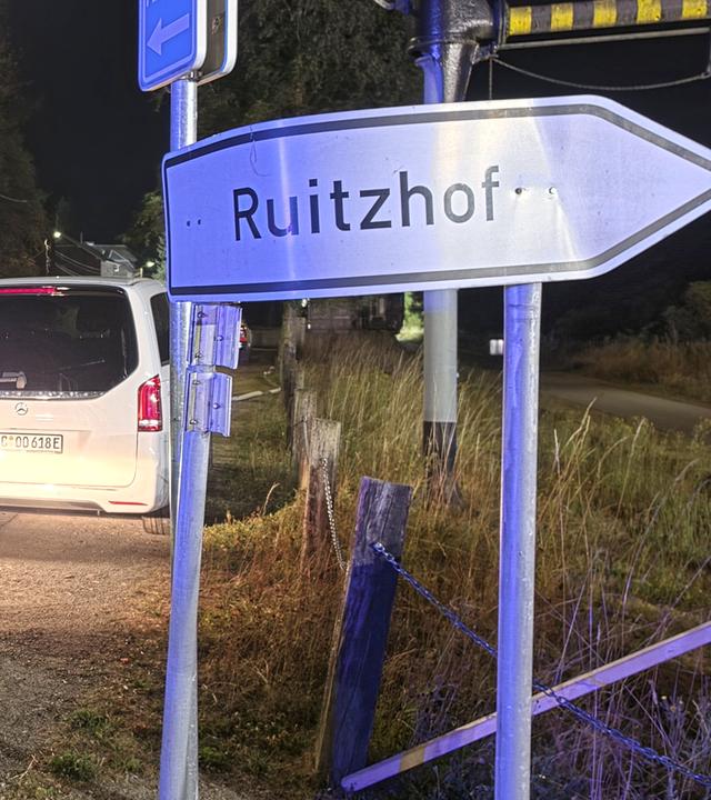Ein Polizeifahrzeug steht im Rahmen von Evakuierungsarbeiten an einem Staßenschild mit der Aufschrift "Ruitzhof".