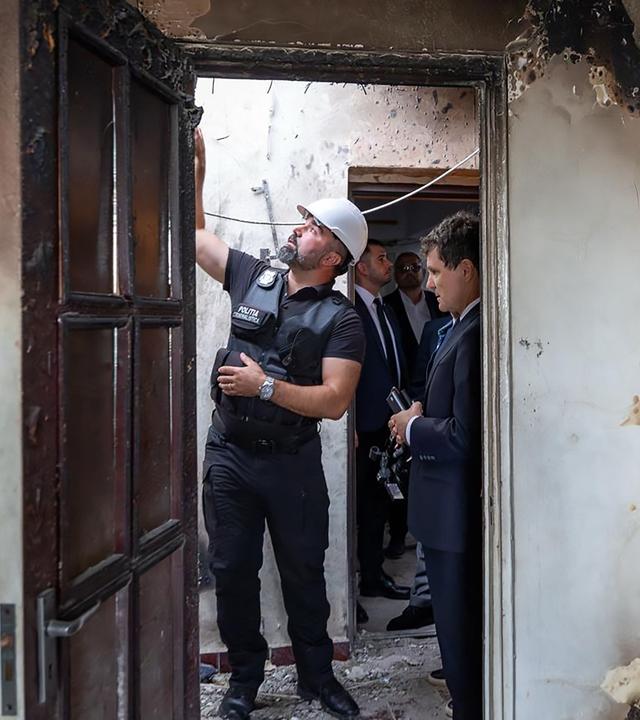Der rumänische Präsident Nicusor Dan begutachtet die Schäden in einem Wohnhaus in Galati, das von einer Drohne getroffen wurde.
