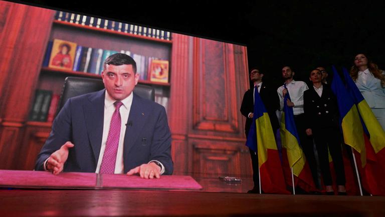 George Simion auf einem Bildschirm bei der Präsidentschaftswahl in Rumänien