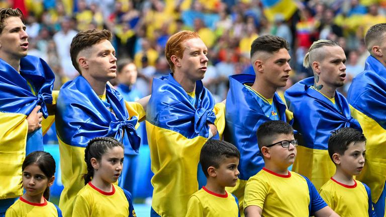 Die Spieler der Ukraine stellen sich vor dem Fußballspiel der UEFA Euro 2024 Gruppe E zwischen Rumänien und der Ukraine in der Münchner Fußballarena am 17. Juni 2024 auf