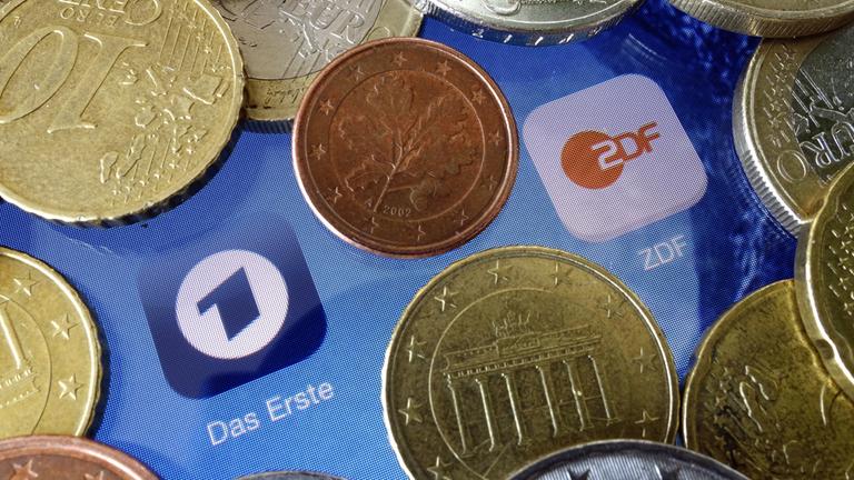 Euromünzen liegen neben den Logos der Apps von ARD und ZDF