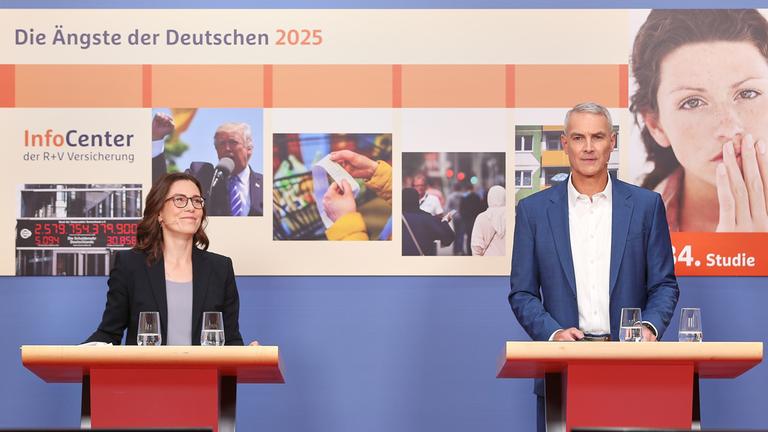 Eine Pressekonferenz. Zwei Menschen stehen an Rednerpulten. Im Hintergrund sind Abbildungen zur Studie