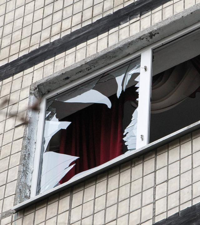 Ein Fenster in einem 14-stöckigen Wohnblock in Dnipro, Ukraine, wird am 24. März 2026 durch einen russischen Drohnenangriff zertrümmert.