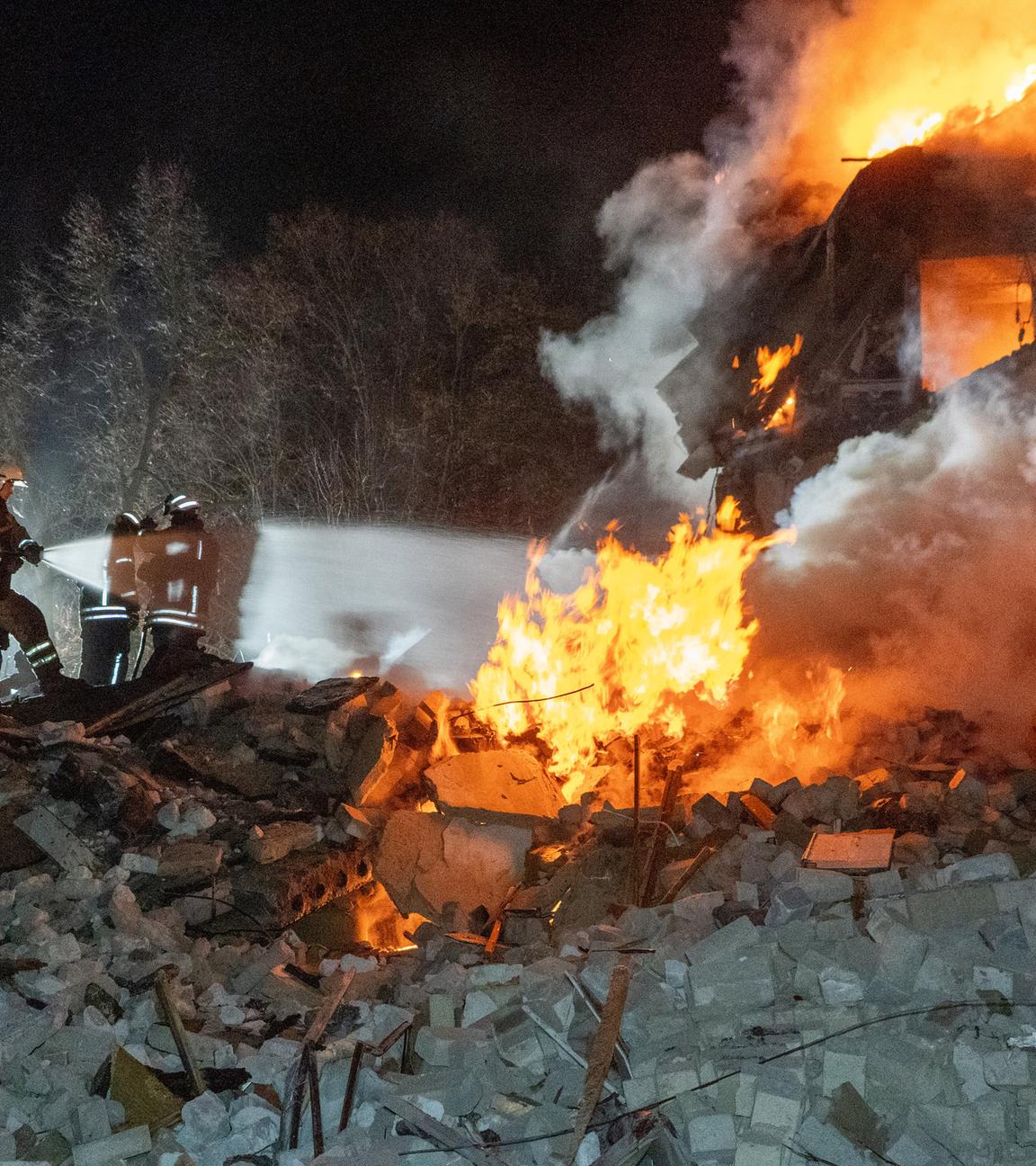 07.03.2026, Ukraine, Charkiw: Feuerwehrleute löschen das Feuer in einem mehrstöckigen Wohnhaus nach einem russischen Raketenangriff in Charkiw, Ukraine.