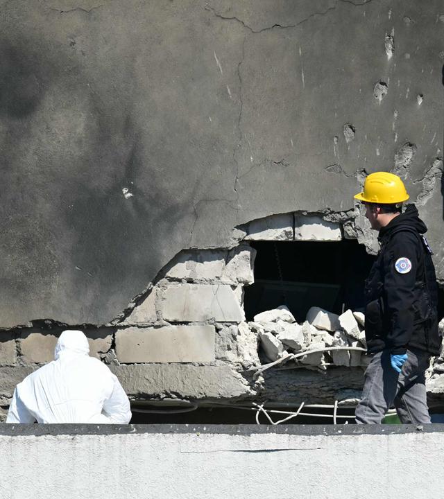 Polizei und Forensiker untersuchen die Einschlagstelle, nachdem eine russische Drohne ein Wohnhaus in Galați im Westen Rumäniens getroffen hat. 