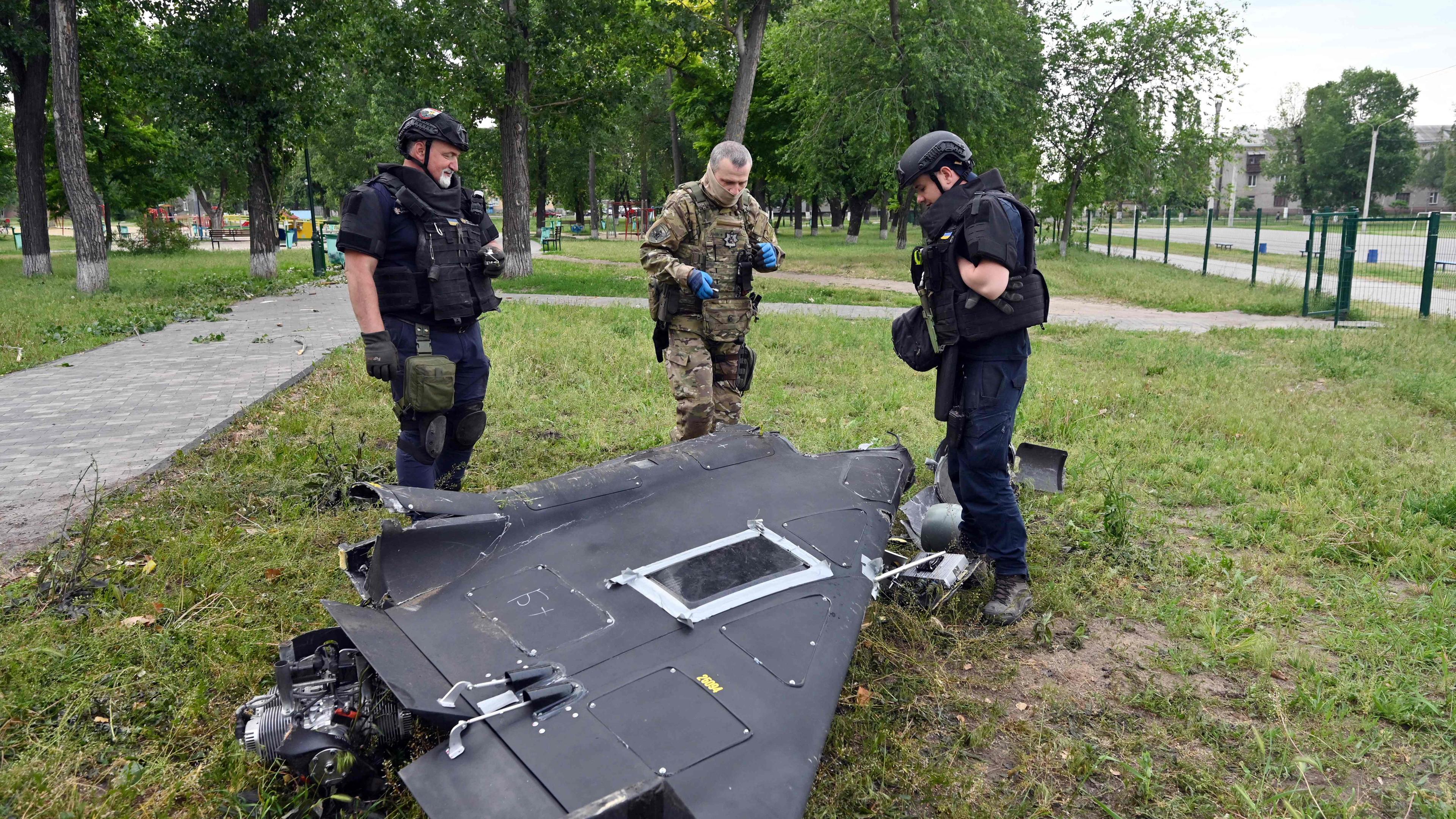 Ukrainische Sprengstoffexperten und Polizisten untersuchen Teile einer Militärdrohne vom Typ Shahed 136 nach einem Luftangriff in Charkiw