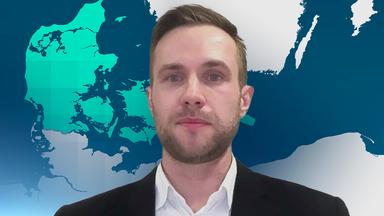 Julian Pawlak, Experte für maritime Sicherheit bei der Stiftung für Wissenschaft und Politikin einem schwarzen Sakko und weißem Hemd. Im hintergrund ist eine weiße Wand.