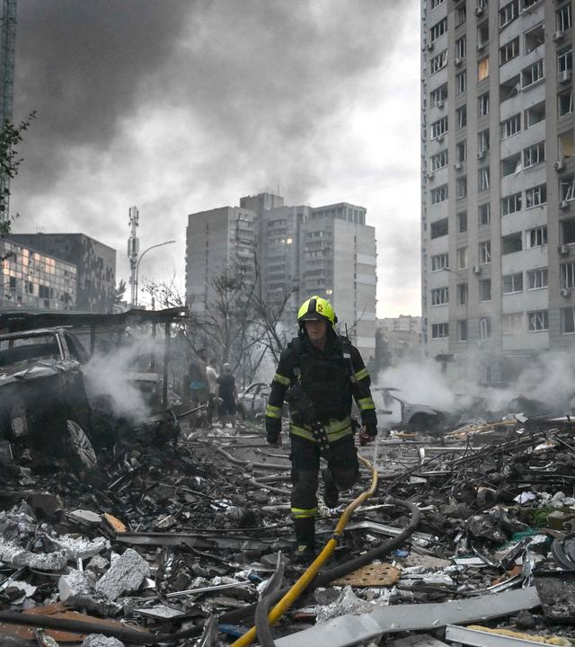 Ukraine: Kiew: Ein Feuerwehrmann geht nach dem russischen Luftangriff durch Trümmer.