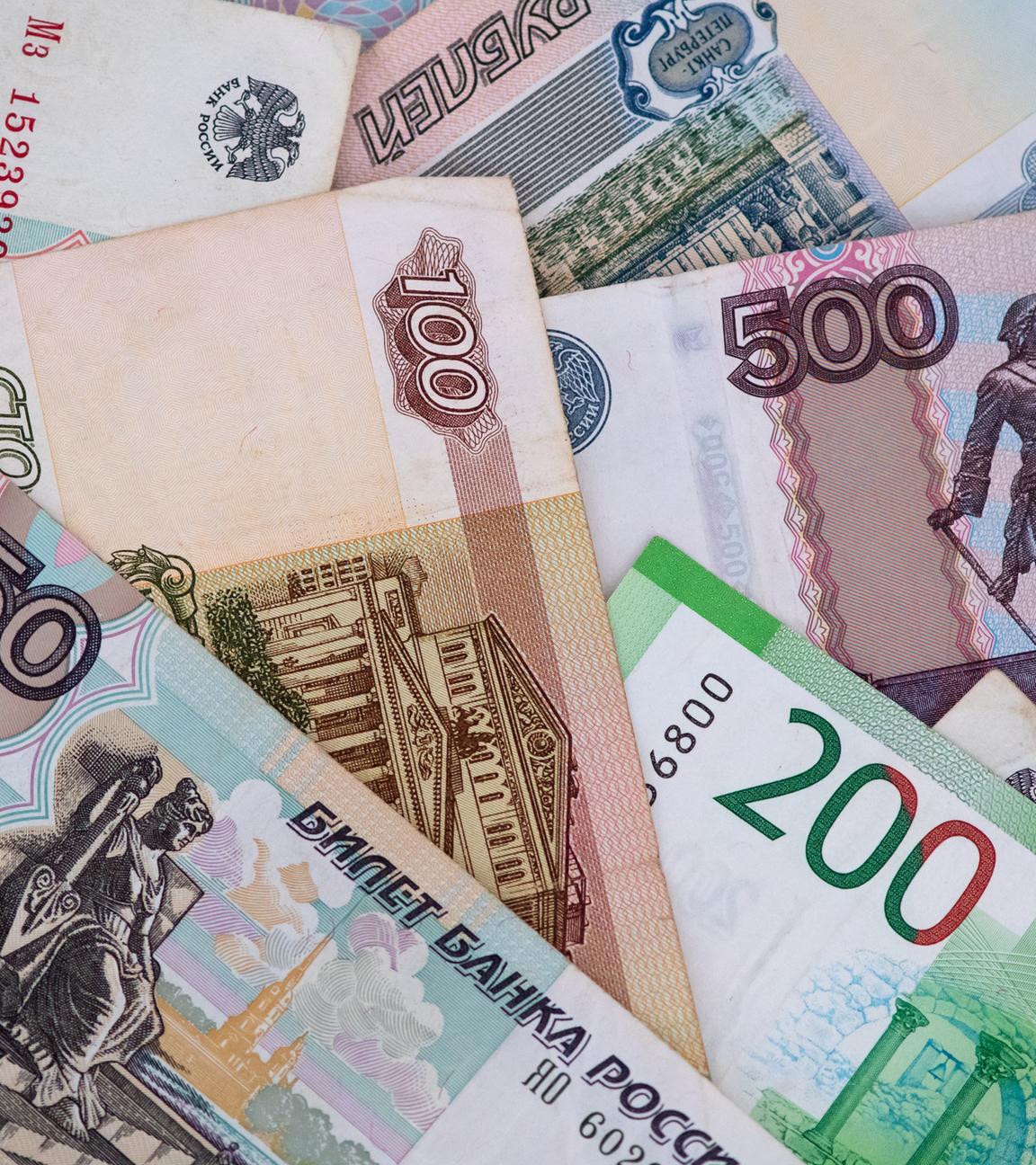 Russische Rubel-Banknoten liegen auf einem Tisch. 