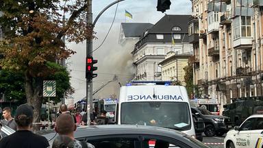 Zuschauer beobachten, wie ukrainische Rettungskräfte nach einem Luftangriff in Kiew am 04.09.2026 im Zuge der russischen Invasion in der Ukraine daran arbeiten, einen Brand im Hauptquartier des Sicherheitsdienstes der Ukraine (SBU) zu löschen. 