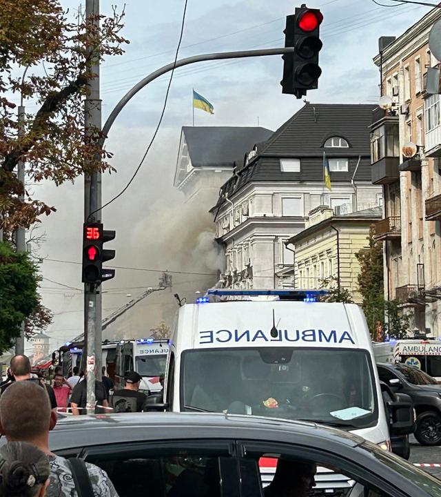 Zuschauer beobachten, wie ukrainische Rettungskräfte nach einem Luftangriff in Kiew am 04.09.2026 im Zuge der russischen Invasion in der Ukraine daran arbeiten, einen Brand im Hauptquartier des Sicherheitsdienstes der Ukraine (SBU) zu löschen. 