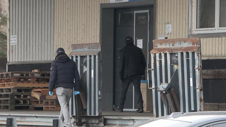 Mehrere Beamte untersuchen eine Lagerhalle