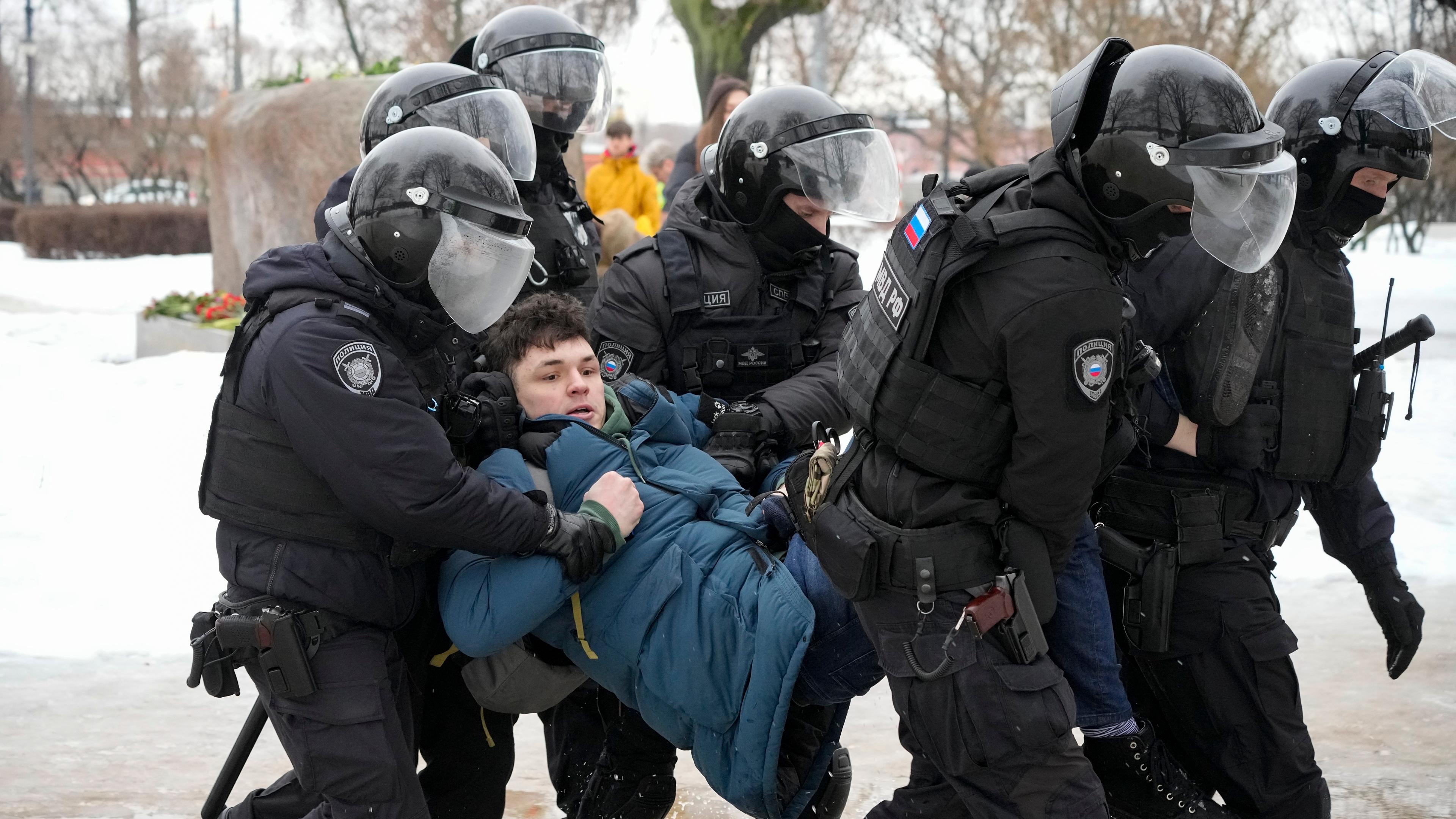 Polizisten in St. Petersburg halten einen Mann fest, als dieser Blumen für Kremlgegner Alexej Nawalny am Denkmal niederlegen will. 