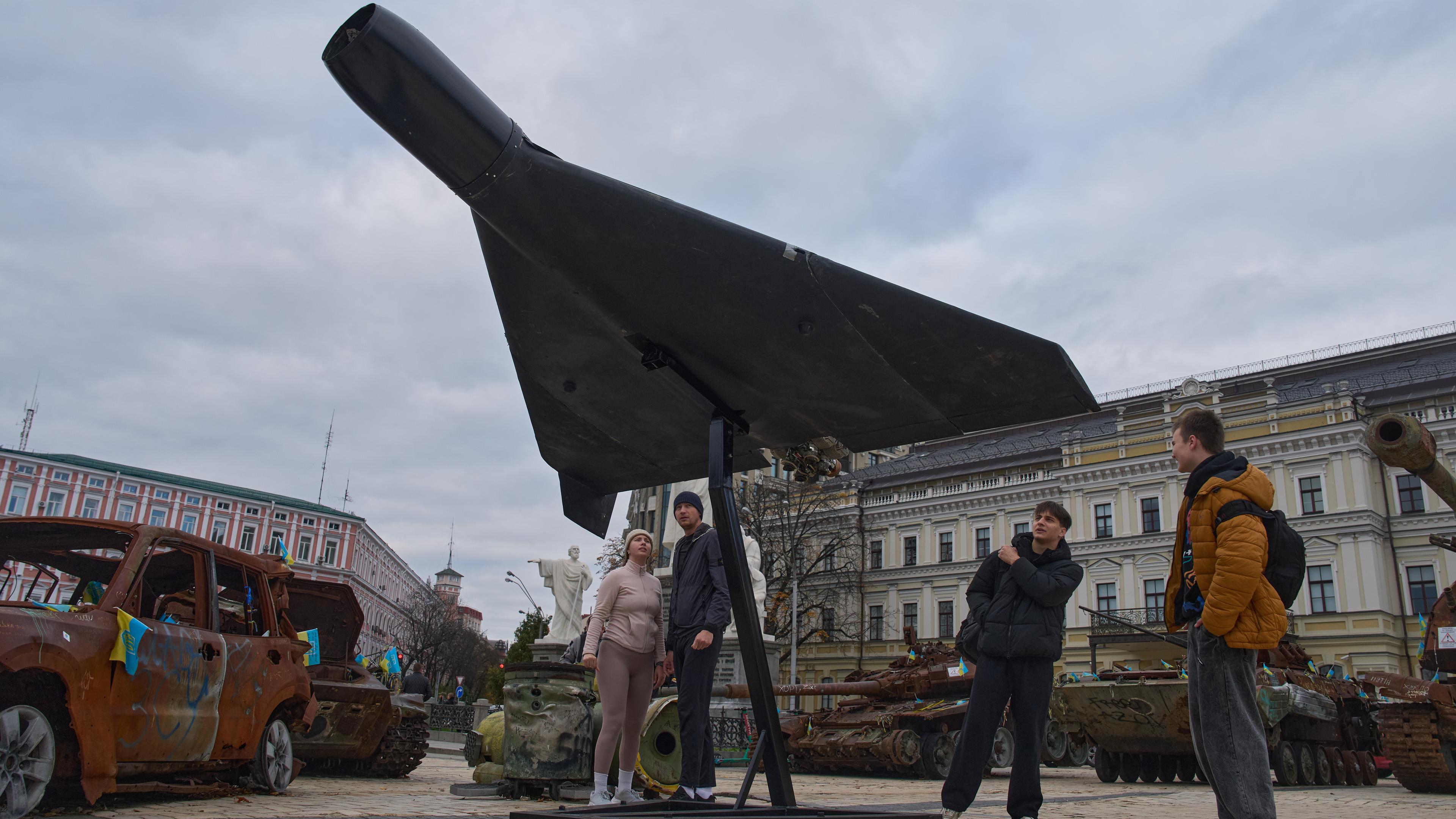 Leute schauen auf eine beschädigte russische Drohne in Kiew, Ukraine.