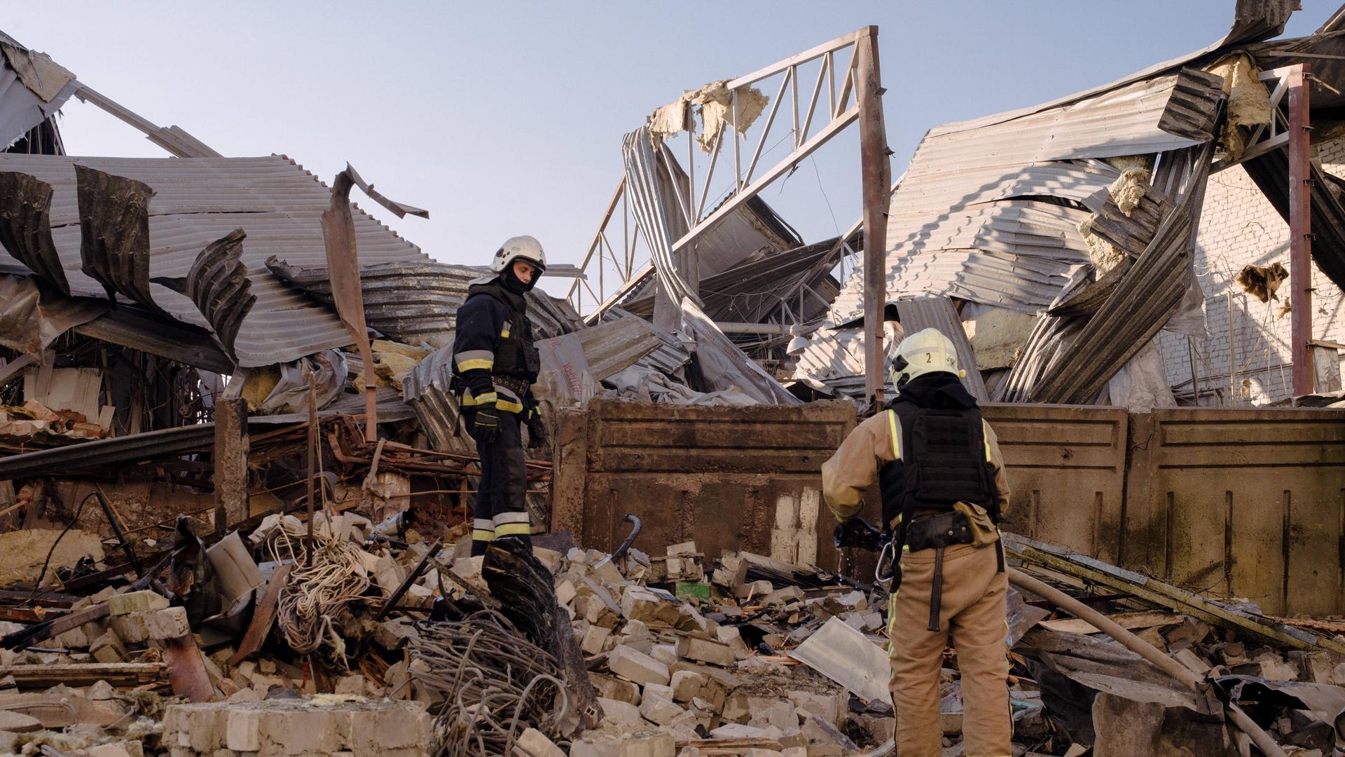 Zwei Feuerwehrmänner laufen über zerstörte Teiles eines Gebäudes in Charkiw, Ukraine, am 07.07.2025.