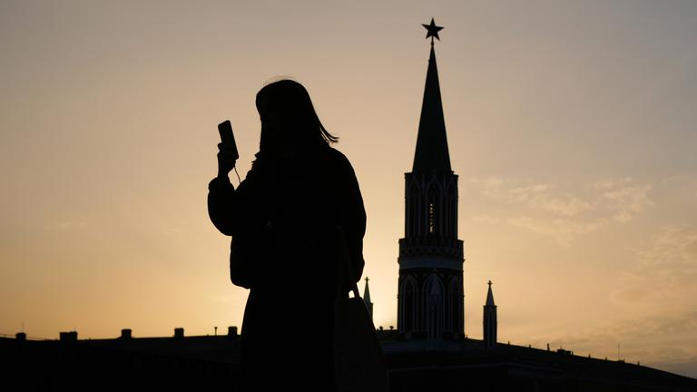 Umriss einer Person mit Handy in der Hand auf dem Roten Platz in Moskau