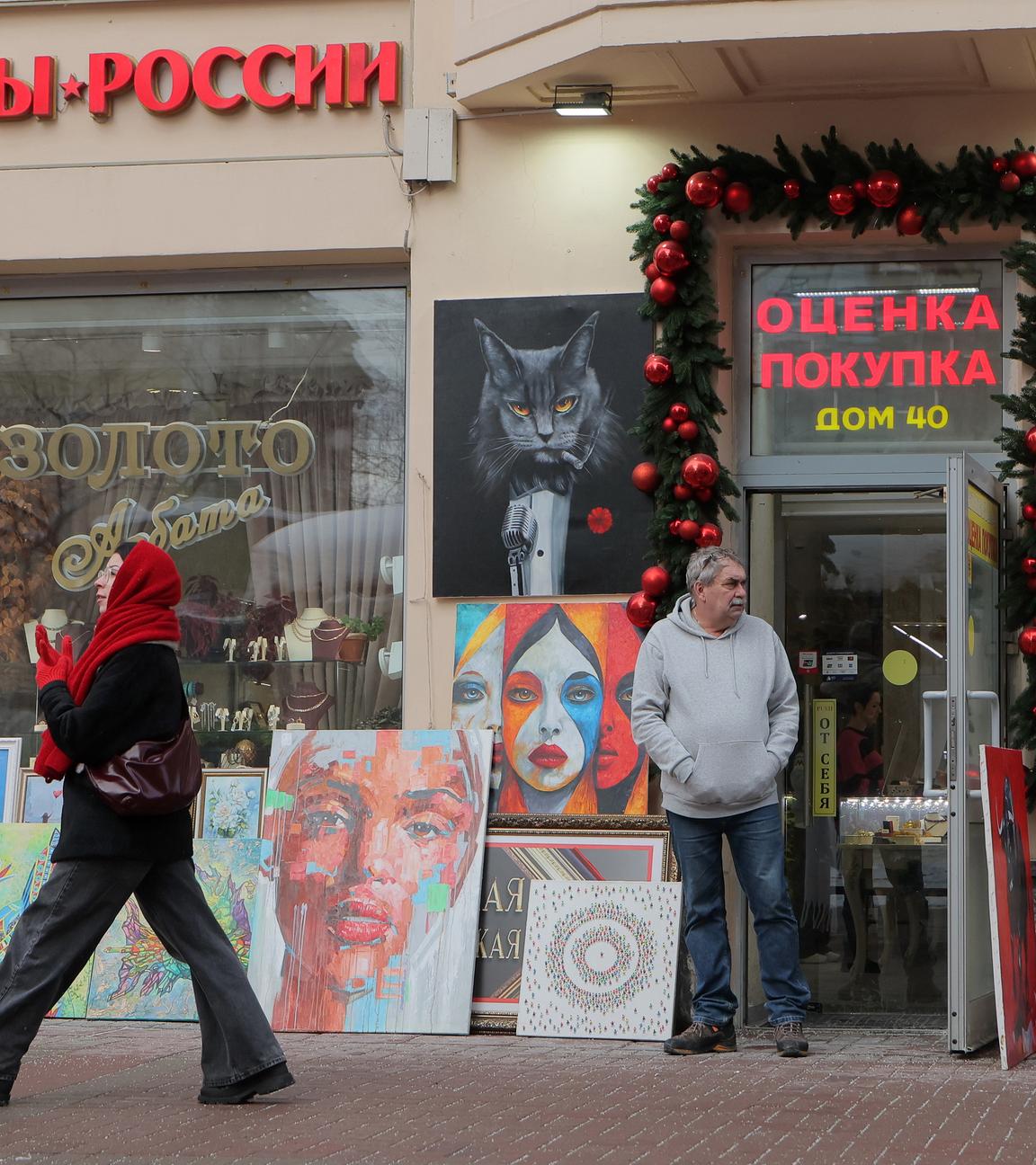 Eine Frau geht an einem Wintertag in Moskau, Russland, auf einer Straße vor einem Souvenirladen entlang.