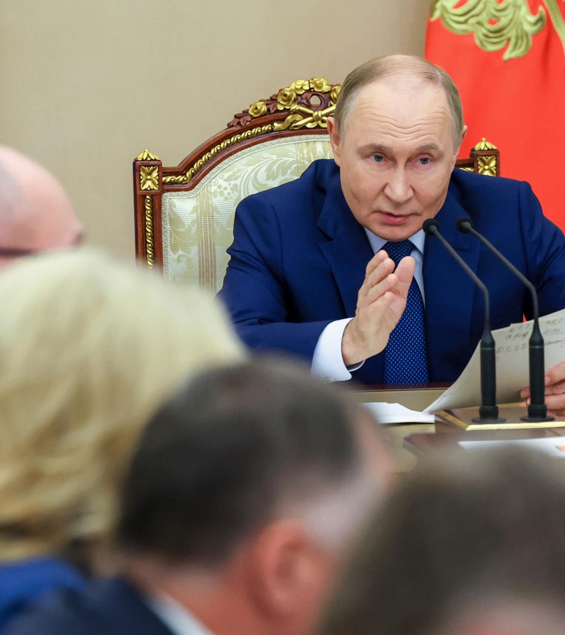 Putin während einer Konferenz/Sitzung an einem Tisch