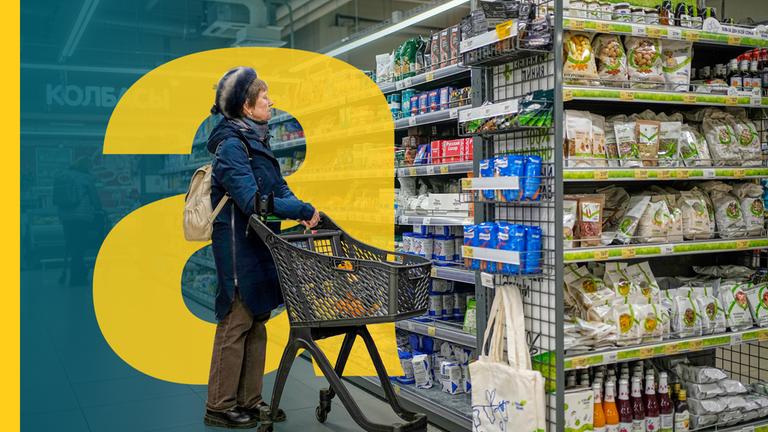 Eine Frau mit einem Einkaufswagen vor einem regal im Supermarkt