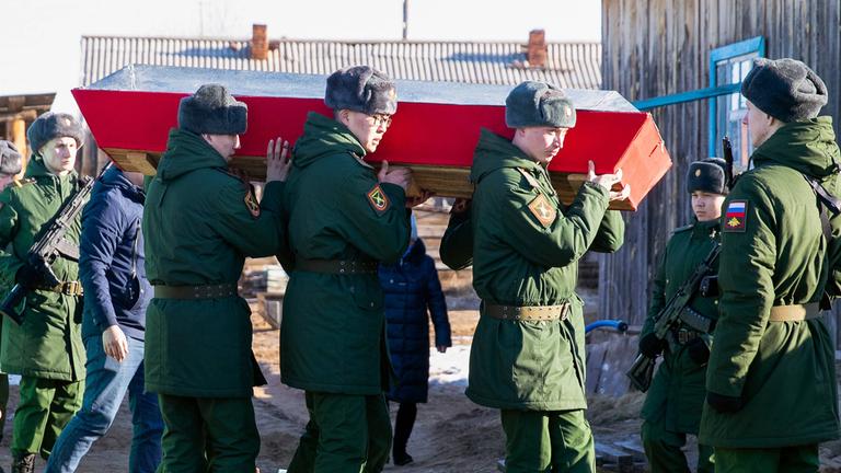 Russische Soldaten tragen einen Sarg