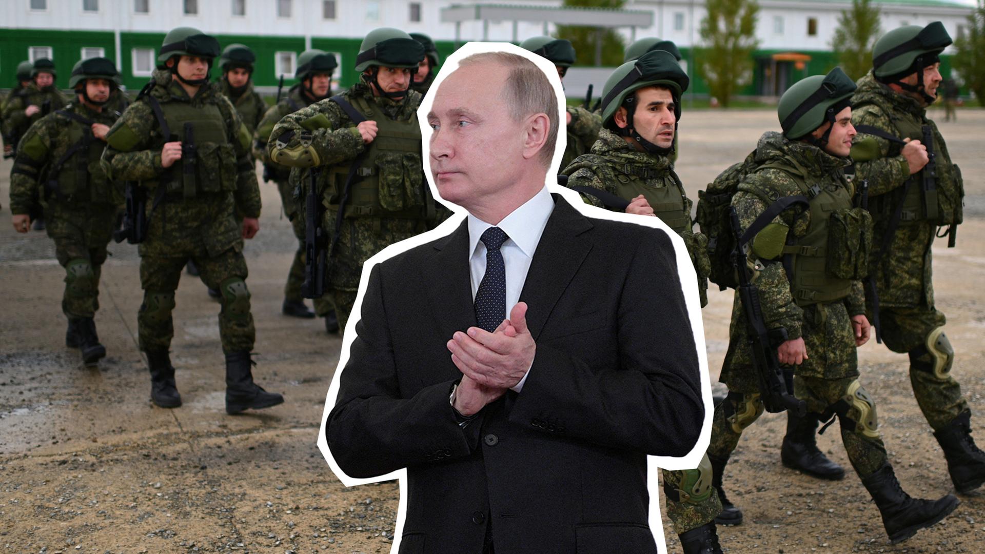 Wladimir Putin, klatschend, und russische Soldaten im Hintergrund