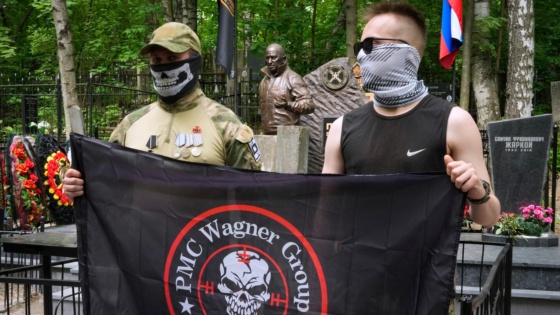 Söldner der "Wagner-Gruppe" posieren für ein Foto neben der Statue des ehemaligen Anführers Jewgeni Prigoschin.