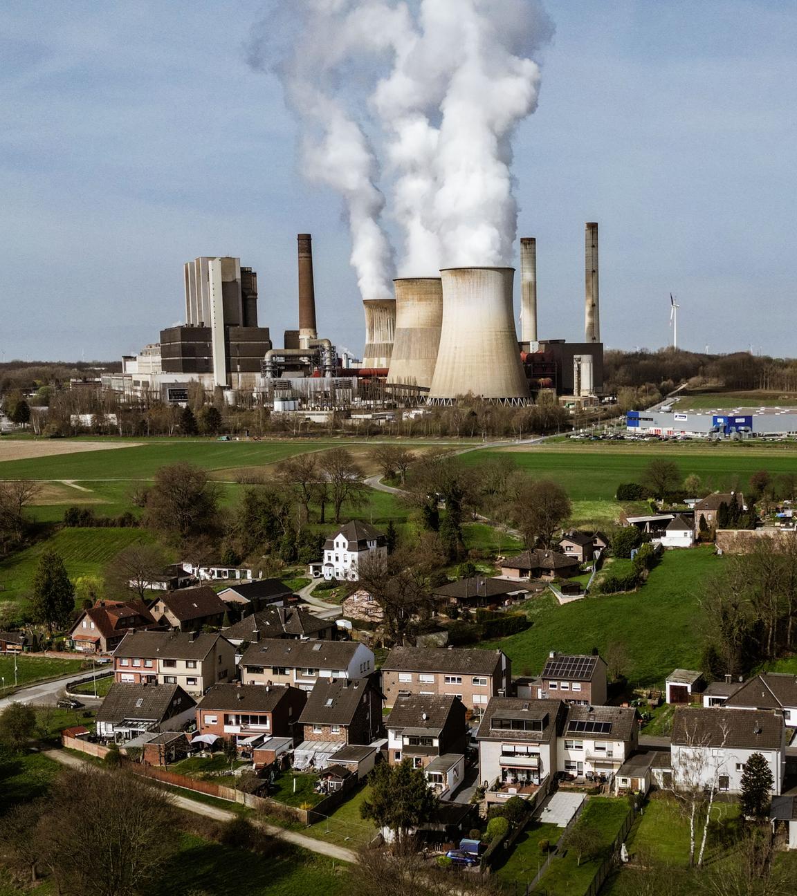 Das RWE Braunkohlekraftwerk Weisweiler im Hintergrund, mit Wohnhäusern mit Vordergrund.