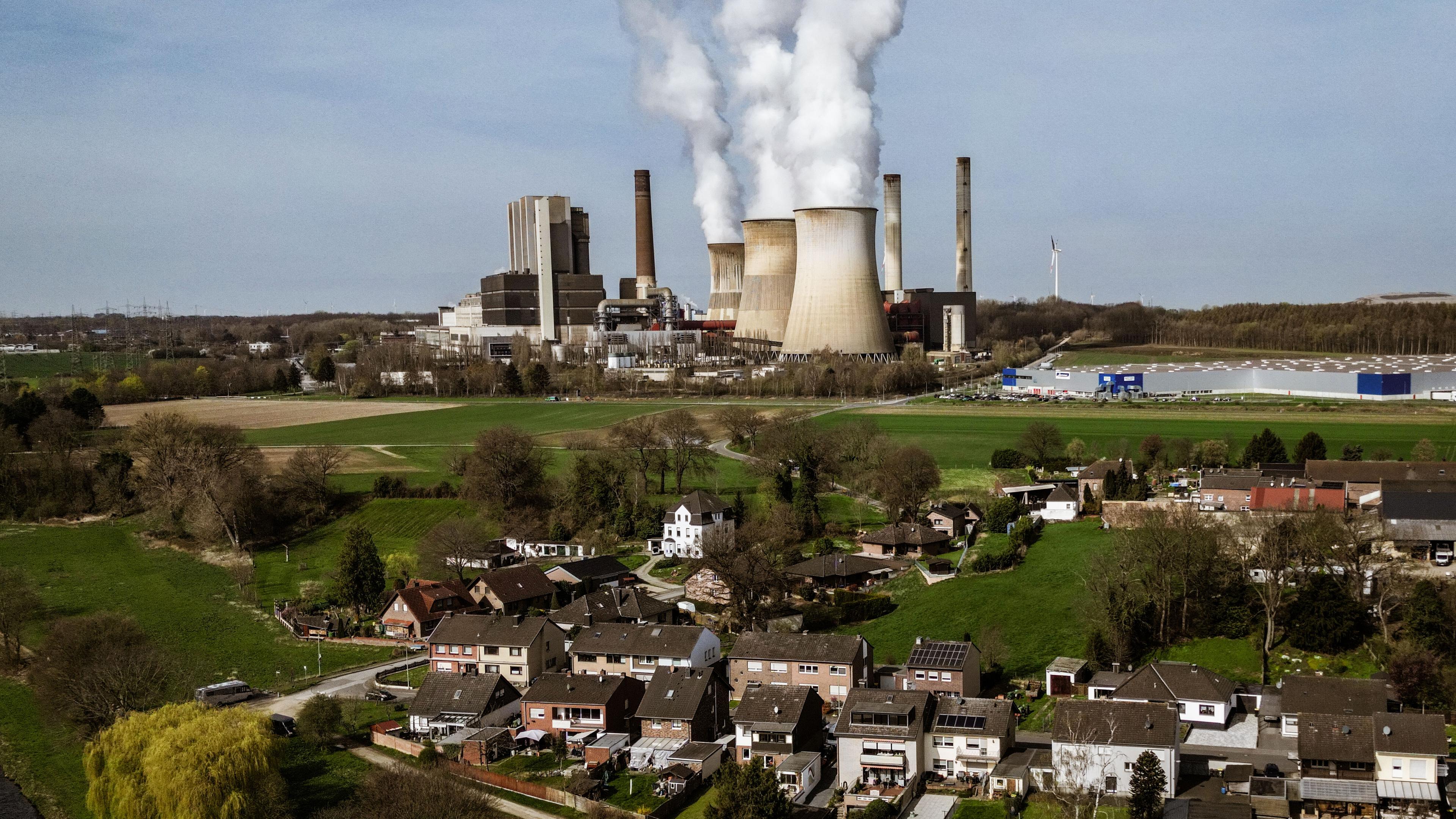Das RWE Braunkohlekraftwerk Weisweiler im Hintergrund, mit Wohnhäusern mit Vordergrund.