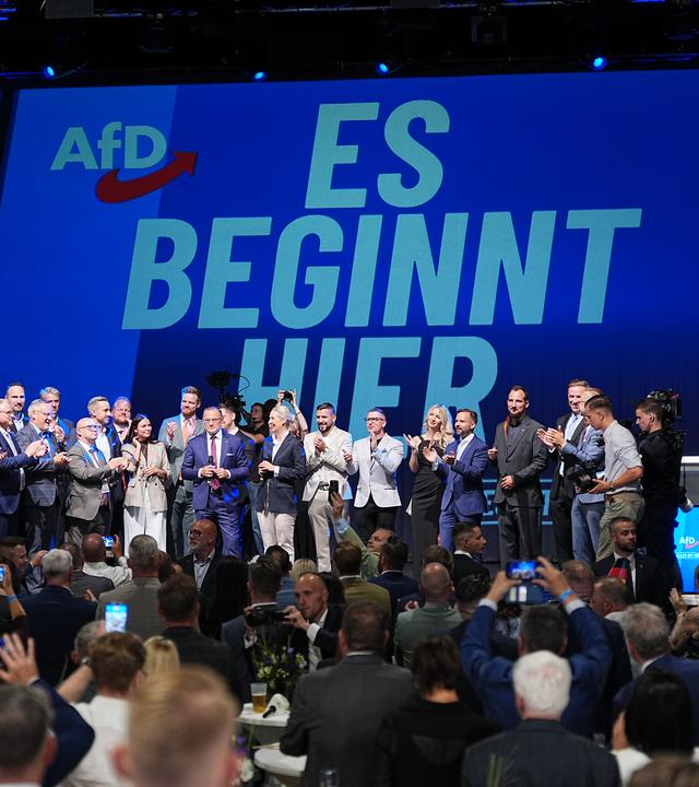 06.09.2026, Sachsen-Anhalt, Magdeburg: Funktionäre der AfD stehen bei der Wahlparty der AfD im Alten Theater vor dem Schriftzug "Es beginnt hier" auf der Bühne.