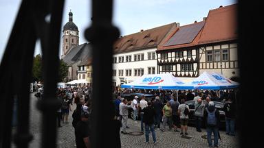 28.08.2026, Sachsen-Anhalt, Sangerhausen: Besucher eines Wahlkampfstandes der AfD auf dem Marktplatz in Sangerhausen stehen in einer Schlange vor dem Zelt mit dem Spitzenkandidaten Siegmund.