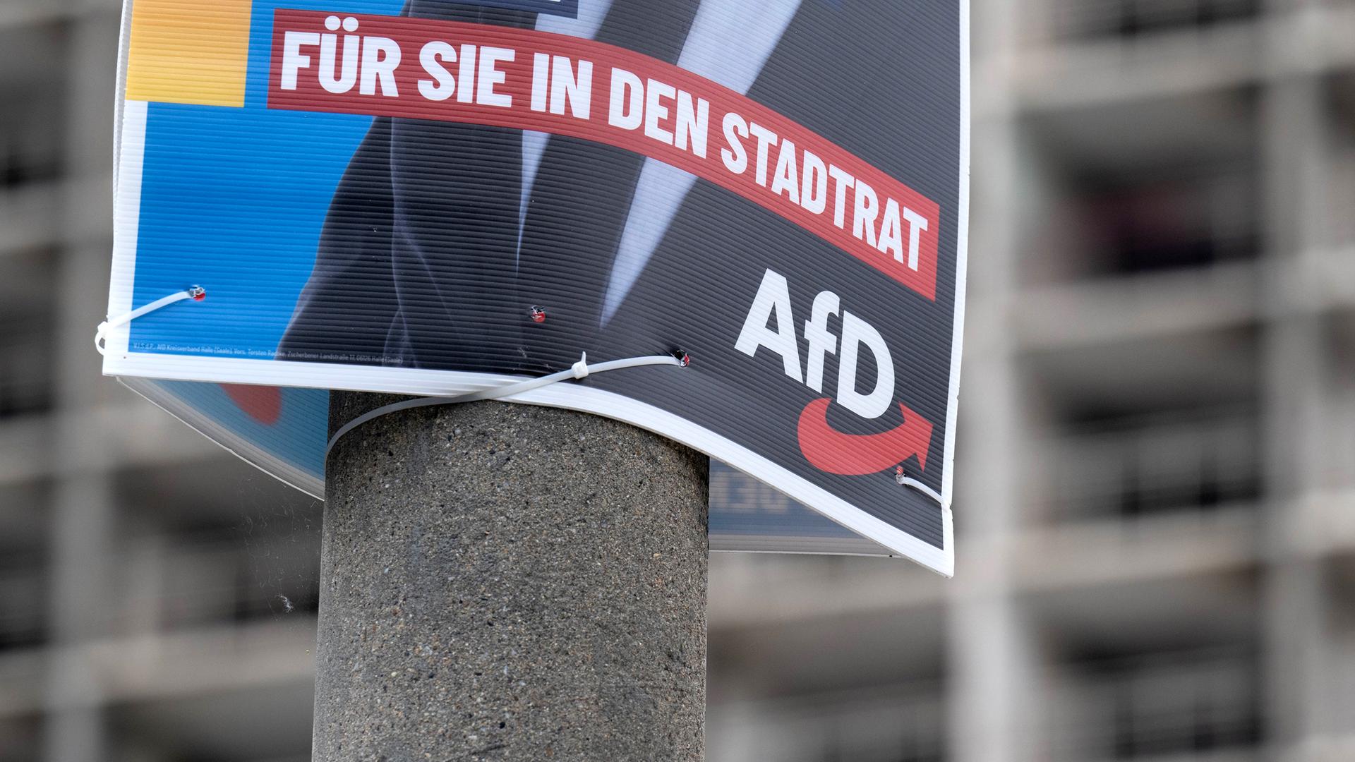 Ein Wahlplakat der AfD zur Kommunalwahl hängt vor einem Neubaublock in Halle/Saale