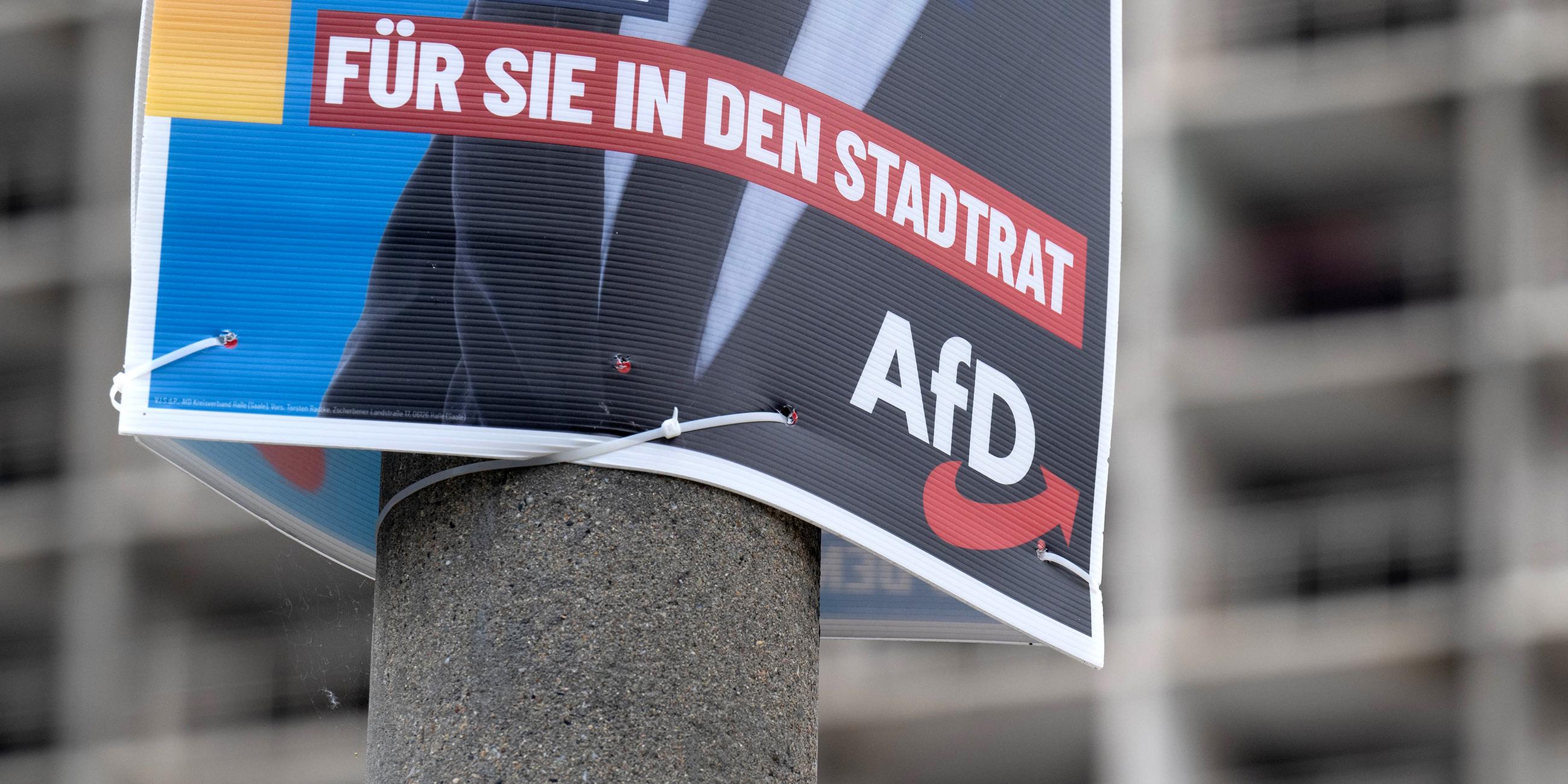 Ein Wahlplakat der AfD zur Kommunalwahl hängt vor einem Neubaublock in Halle/Saale