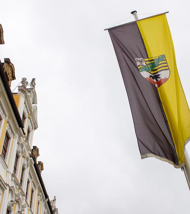 Die Flagge von Sachsen-Anhalt ist vor der Fassade des Gebäudes des Landtags von Sachsen-Anhalt gehisst.