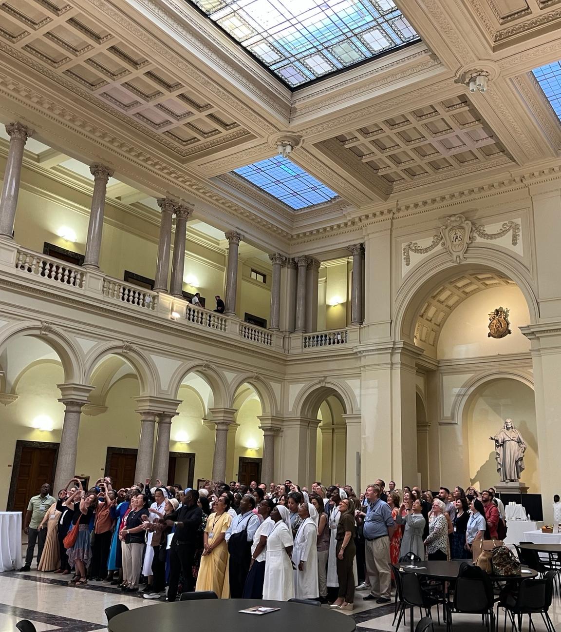 Eine Gruppe von Personen steht eng aneinander in der Mitte einer Kirche