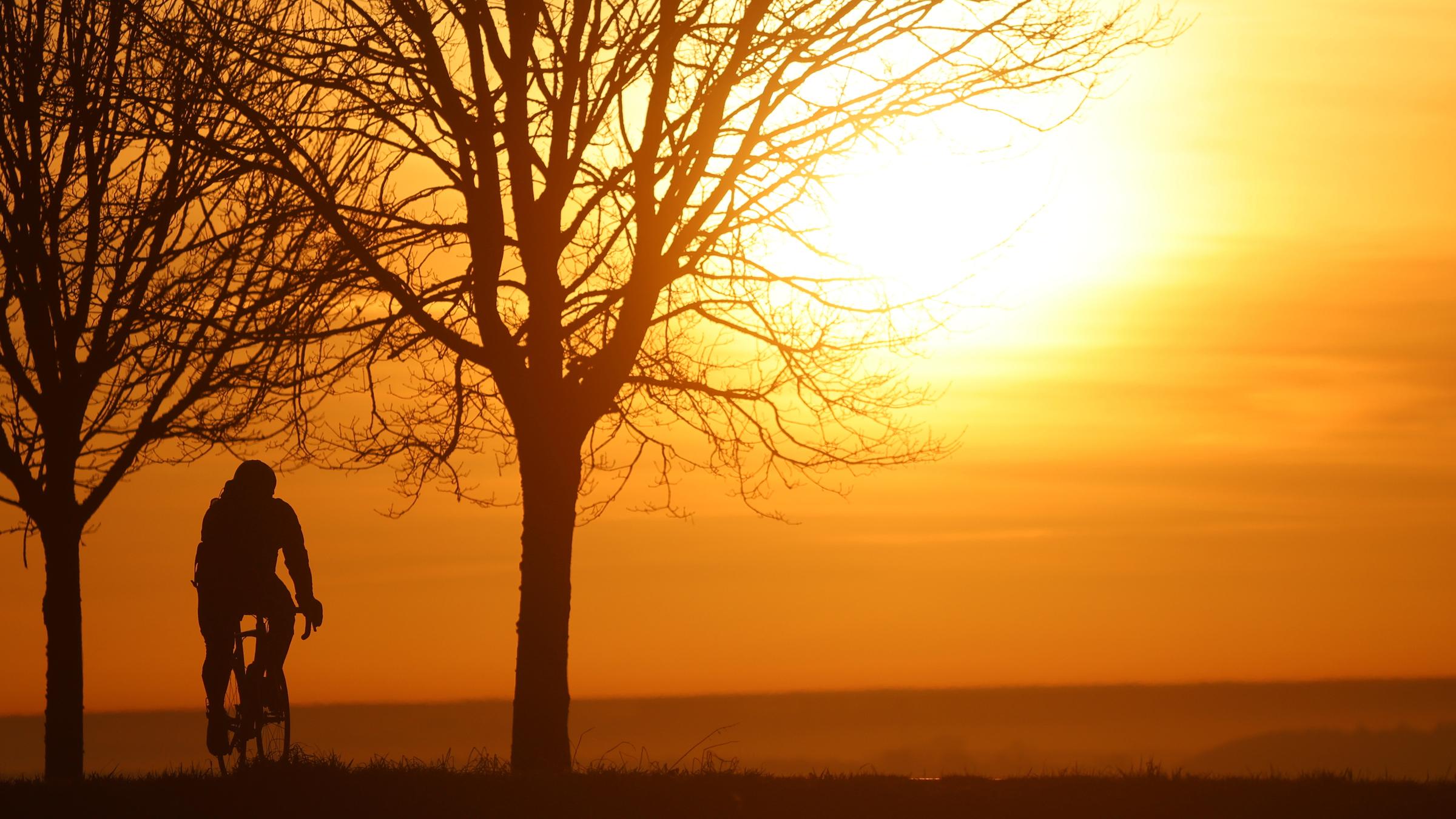 Fahrradfahrer beim Sonnenaufgang im Saharastaub