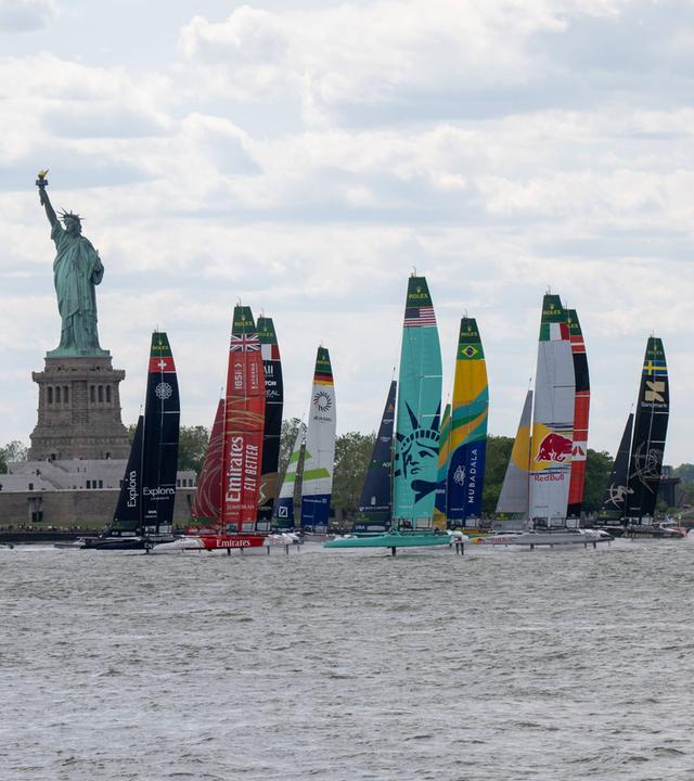 Die Katamarane der Nationalteams segeln beim New York Sail Grand Prix 2026 vor der Freiheitsstatue