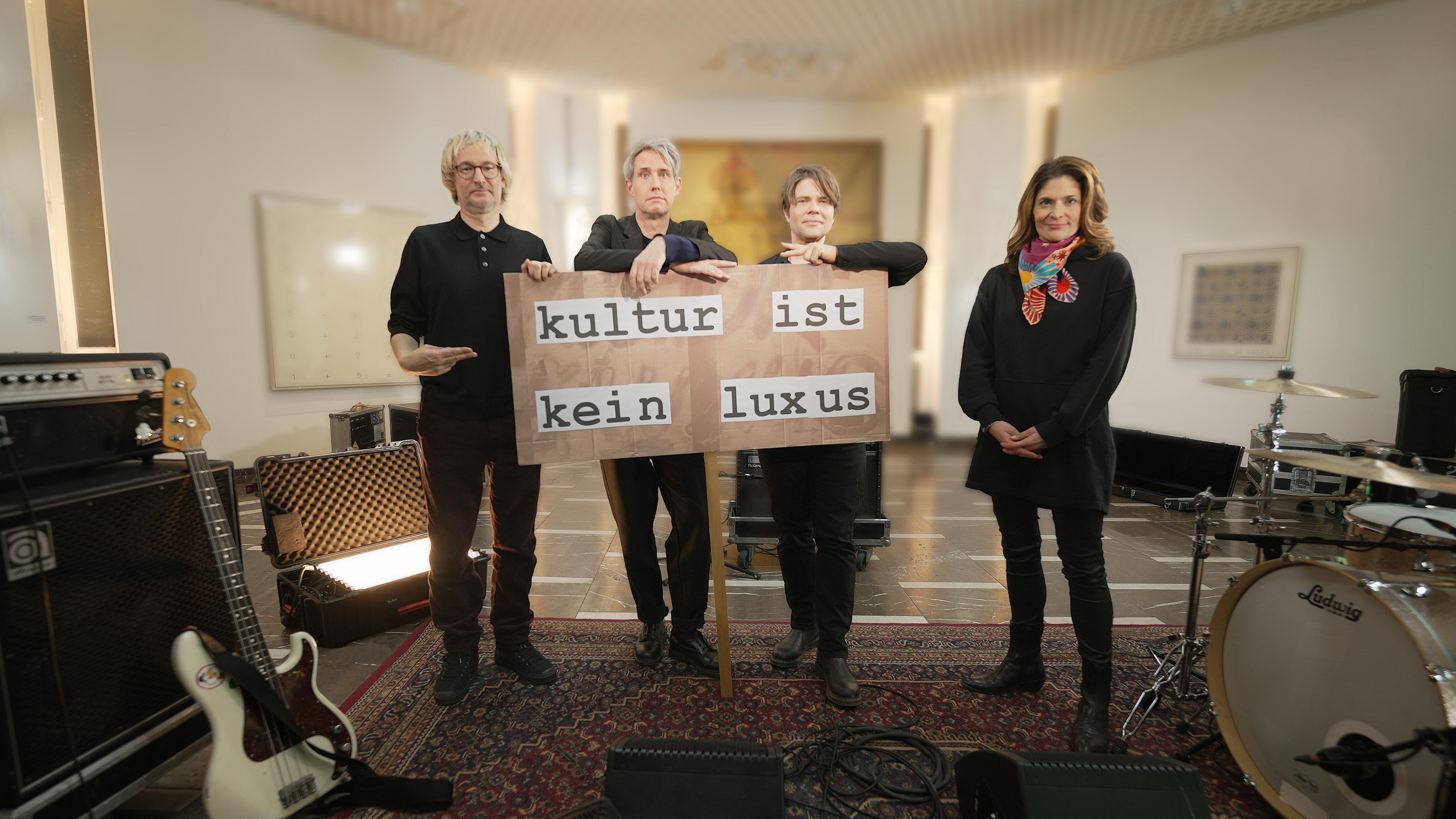 Moderatorin Katty Salié und die Band Tocotronic mit Demoposter "Kultur ist kein Luxus"