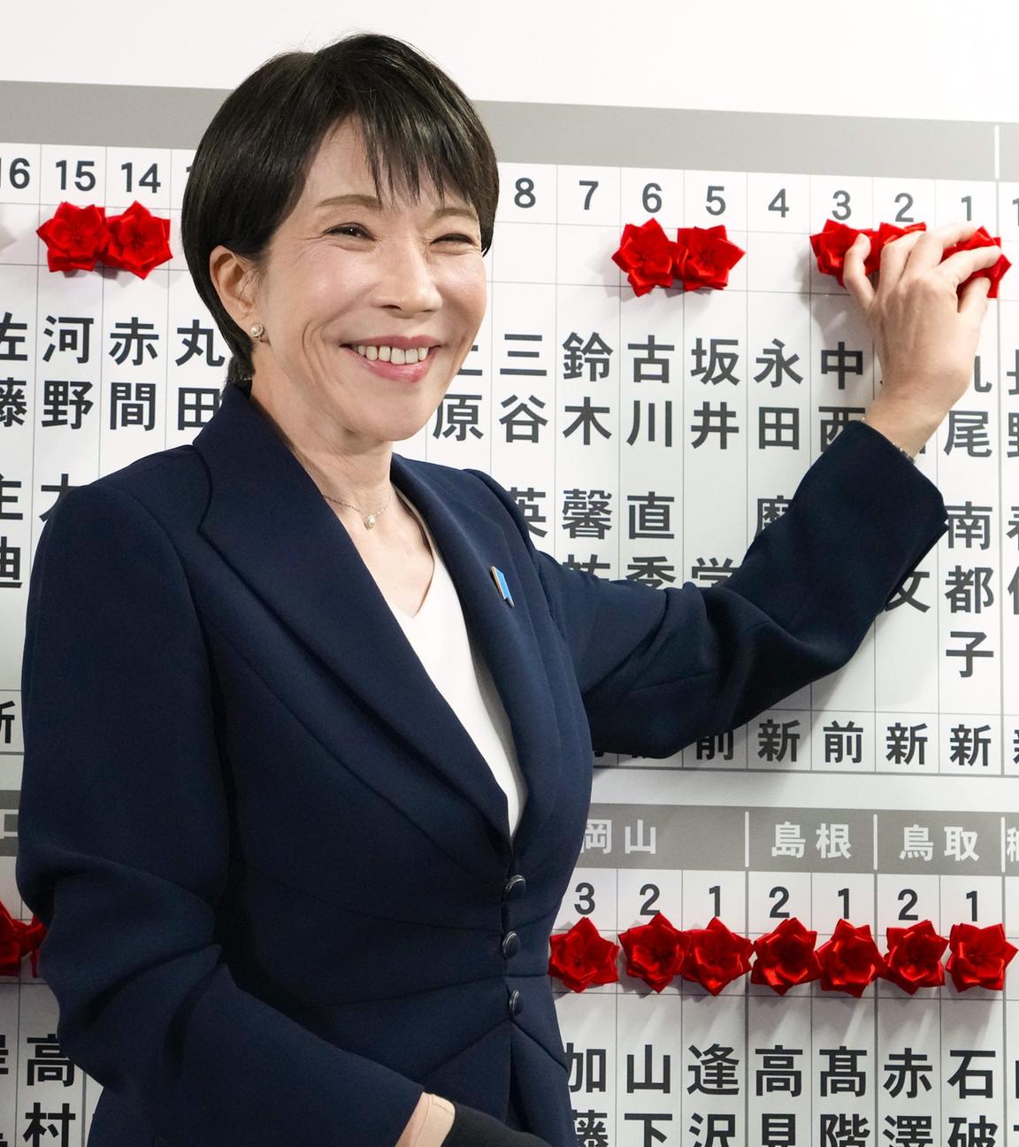Die japanische Premierministerin Sanae Takaichi befestigt am 08.02.2026 nach den Parlamentswahlen in der Parteizentrale in Tokio eine Rosette am Namen eines Kandidaten der Liberaldemokratischen Partei, dessen Sieg sicher ist. 