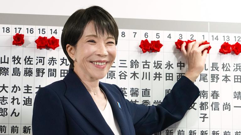 Die japanische Premierministerin Sanae Takaichi befestigt am 08.02.2026 nach den Parlamentswahlen in der Parteizentrale in Tokio eine Rosette am Namen eines Kandidaten der Liberaldemokratischen Partei, dessen Sieg sicher ist. 
