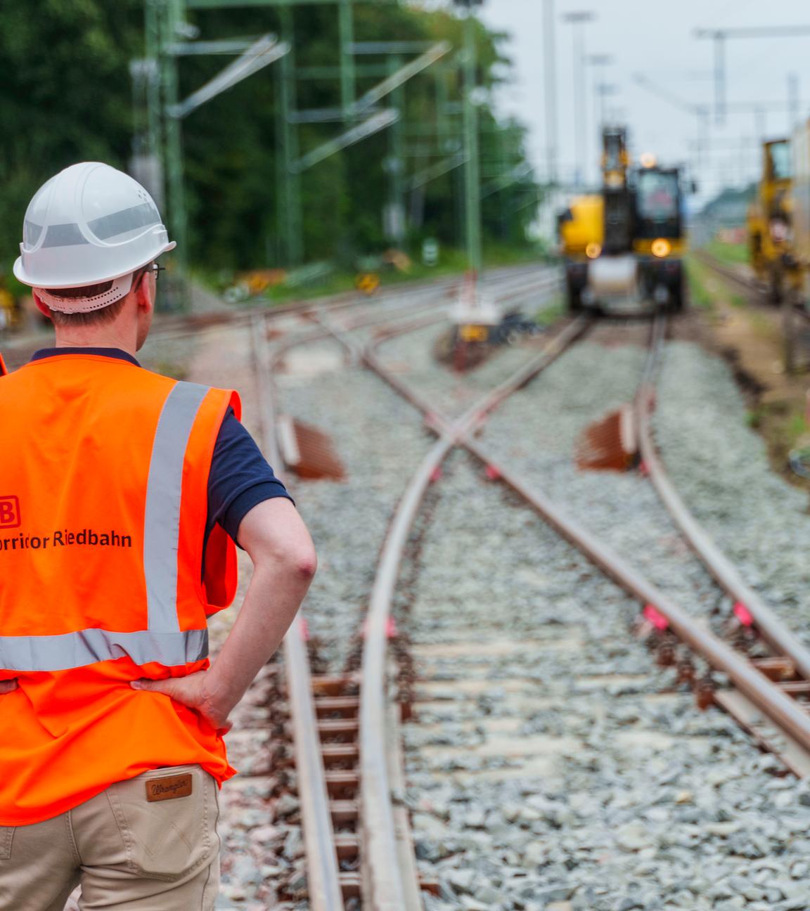 Teilnehmer des Presserundgangs schauen auf die Baustelle im Abschnitt am Bahnhof Mörfelden/Walldorf.