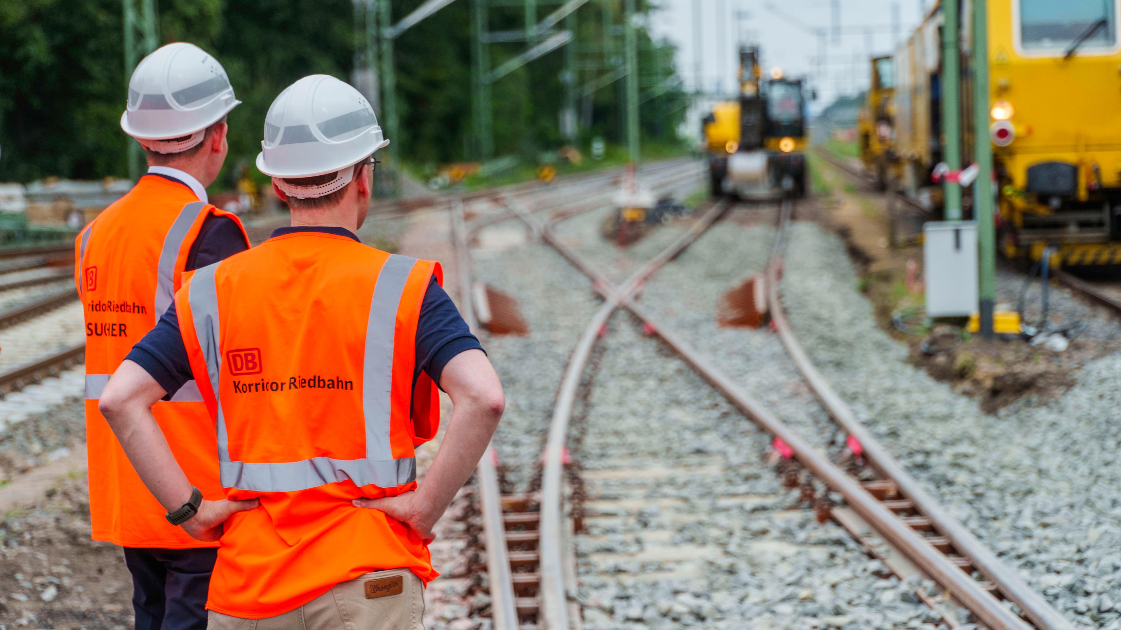 Teilnehmer des Presserundgangs schauen auf die Baustelle im Abschnitt am Bahnhof Mörfelden/Walldorf.