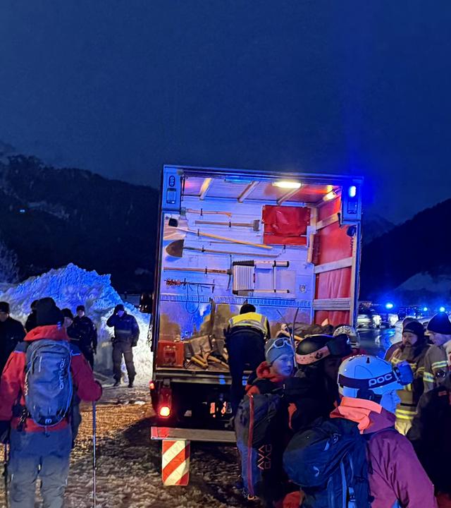 Einsatzkräfte und Helfer stehen bei einem LKW. In St. Anton ging am Freitagnachmittag eine Lawine ab. 