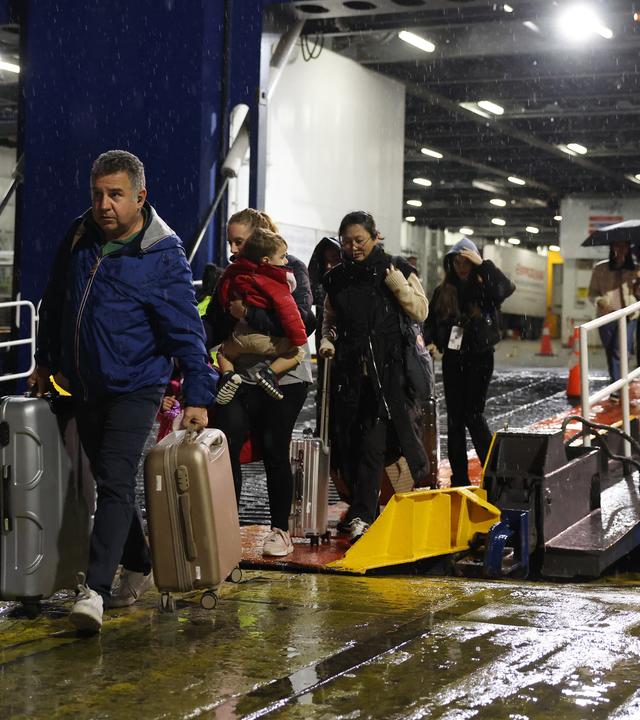 Menschen verlassen eine Fähre in Piraeus