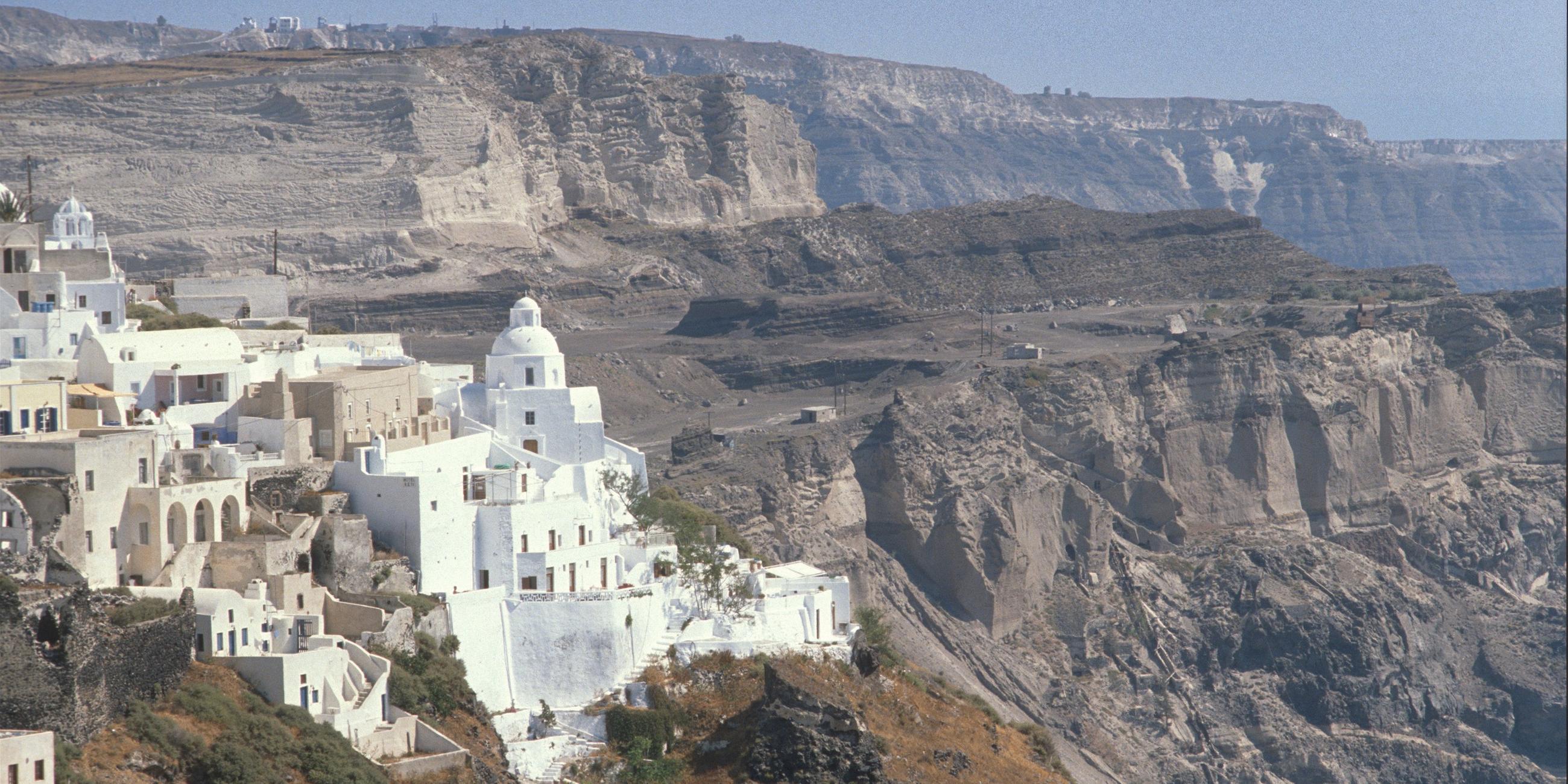 Gebäude auf der Insel Santorini, im Hintergrund Felshänge.