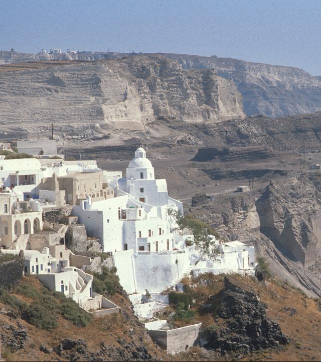 Gebäude auf der Insel Santorini, im Hintergrund Felshänge.