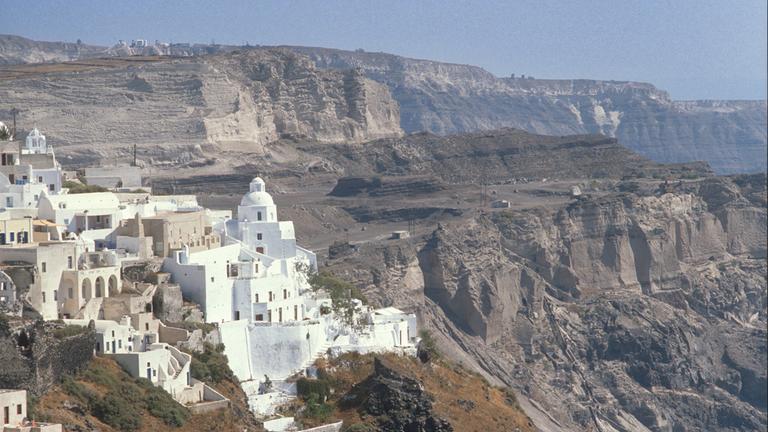 Gebäude auf der Insel Santorini, im Hintergrund Felshänge.