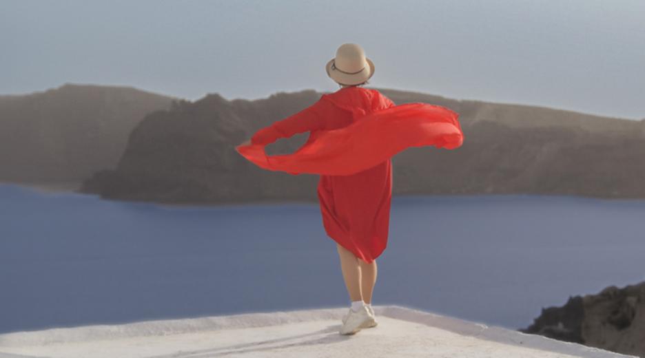 Frau in Griechenland mit roter Tunika und Sonnenhut