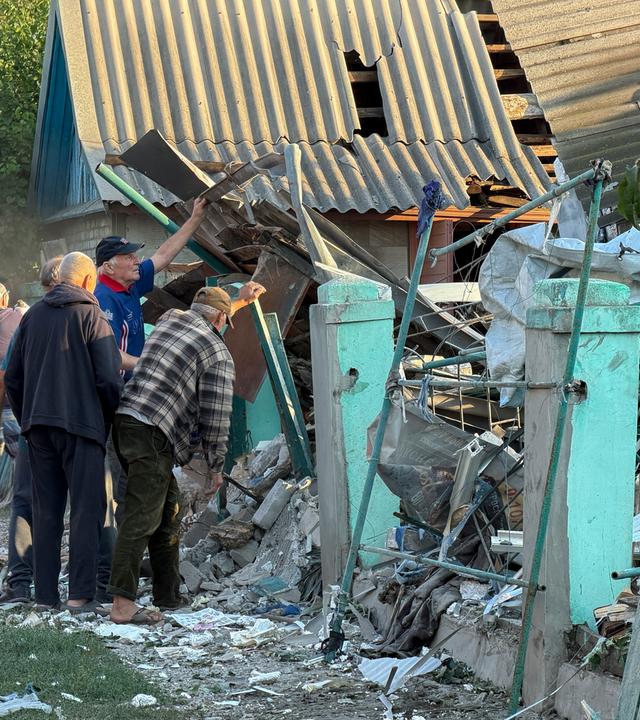 Menschen räumen Trümmer an der Einschlagstelle eines russischen Angriffs auf ein Gebäude in Saporischschja, Ukraine, am 12. September 2026, inmitten der anhaltenden russischen Invasion.