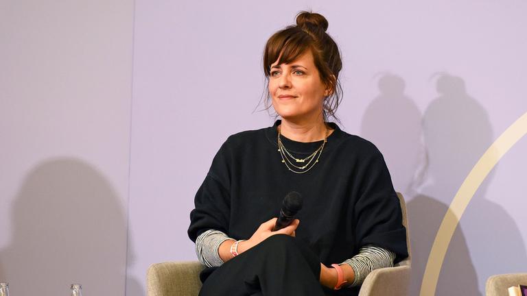 Sarah Kuttner sitzt auf einer Bühne.