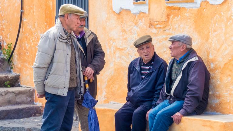 Eine Gruppe Senioren unterhalten sich in einem Dorf auf Sardinien. (Archiv)